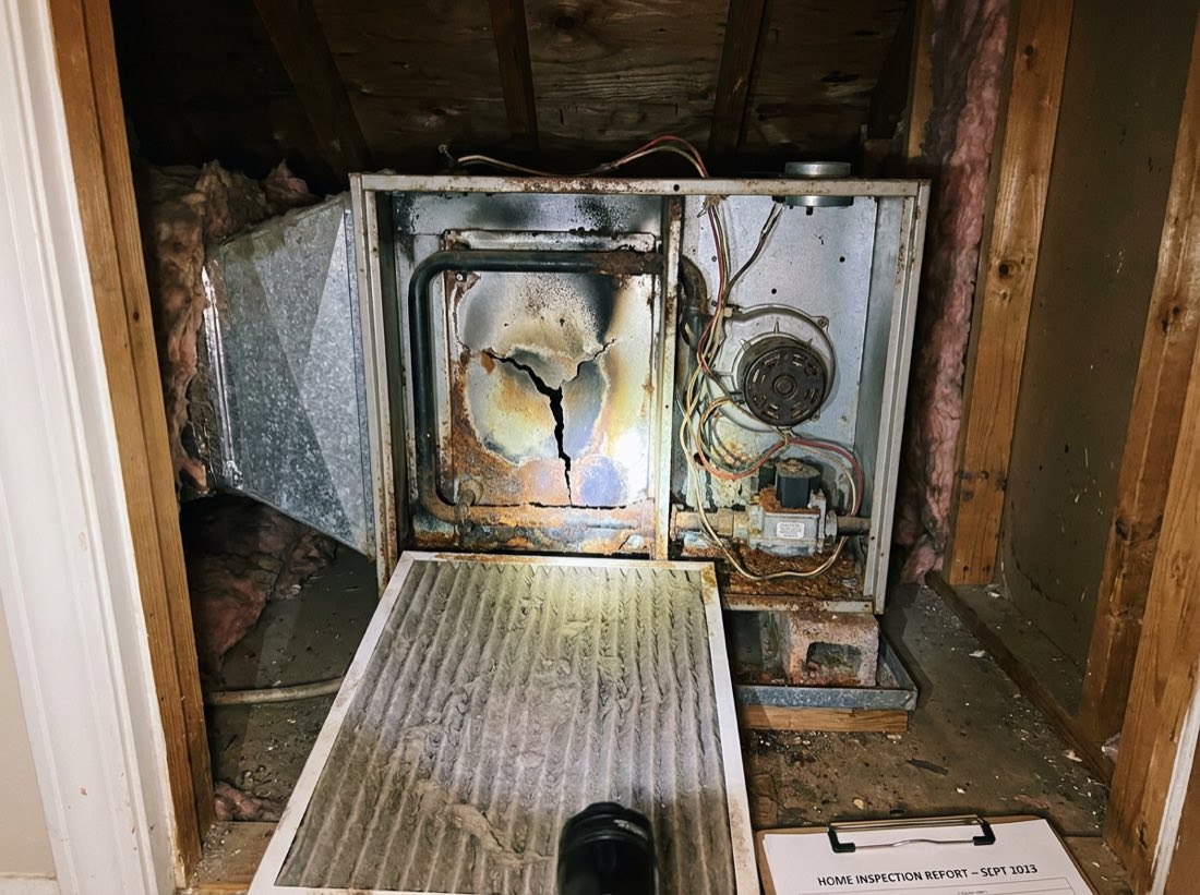 Rusted, aging HVAC furnace with a dirty filter and corroded components