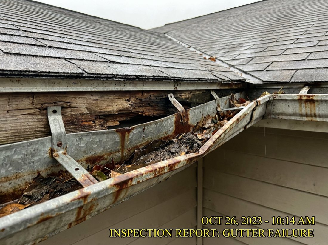 Sagging, rusted gutters overflowing with leaves and pulling away from the fascia